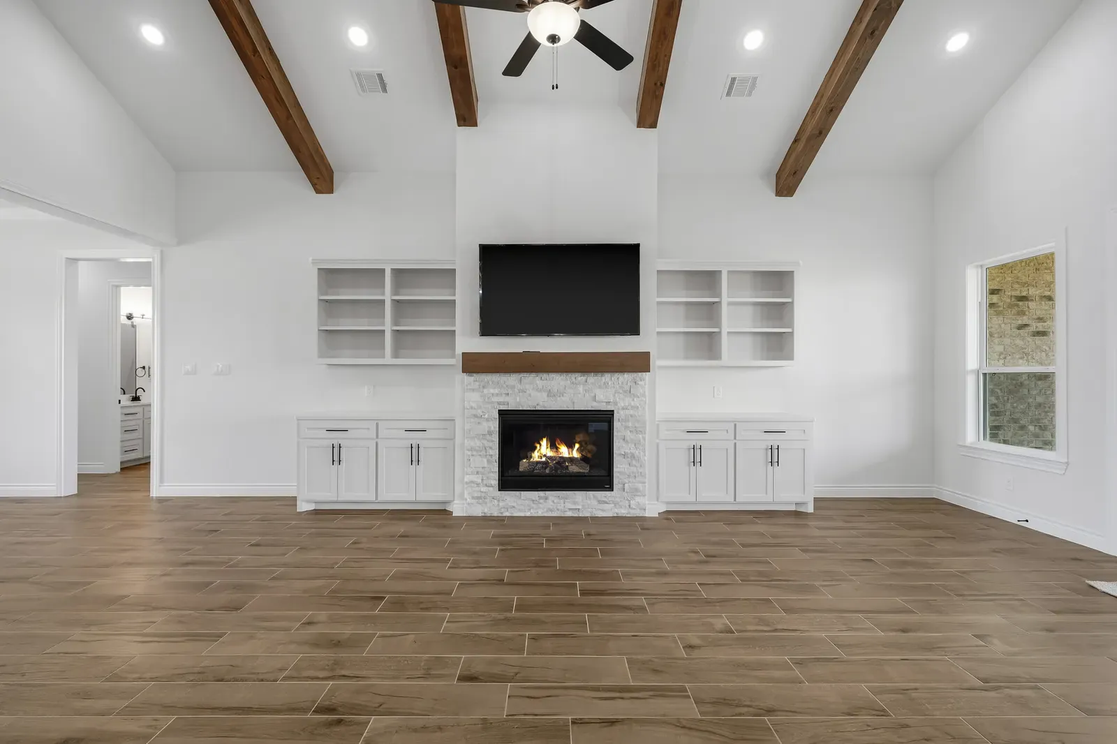 Family room fireplace with built-ins and a beamed, vaulted ceiling