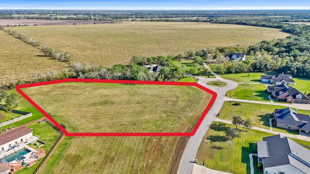 Aerial view of the lot outlined in red, with neighboring homes